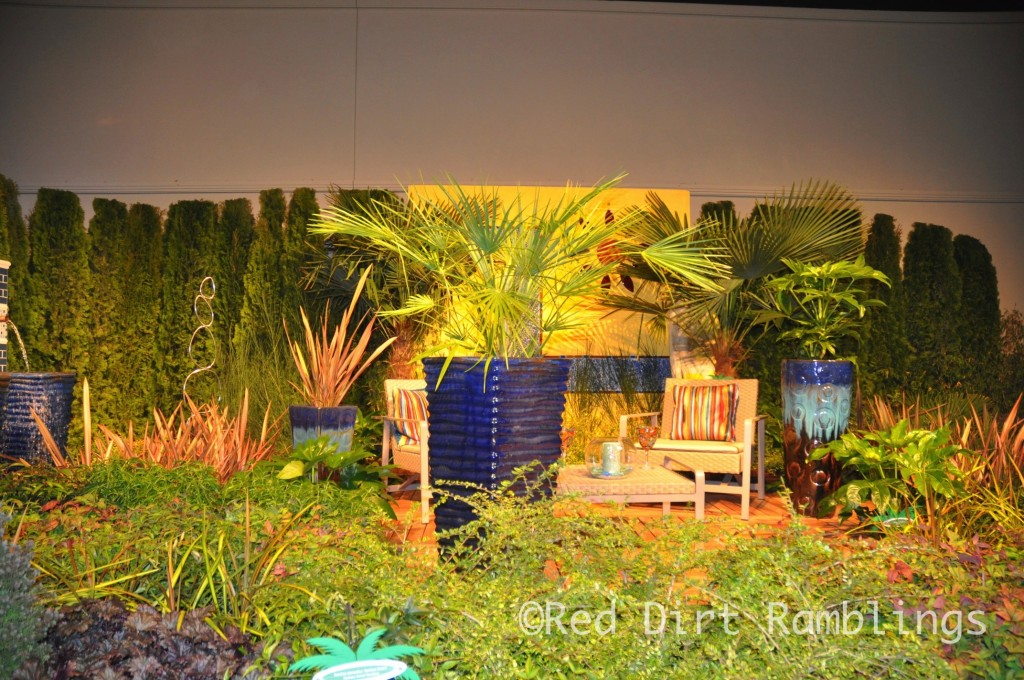 A sunny Mediterranean garden full of hot colors in plants and decor.